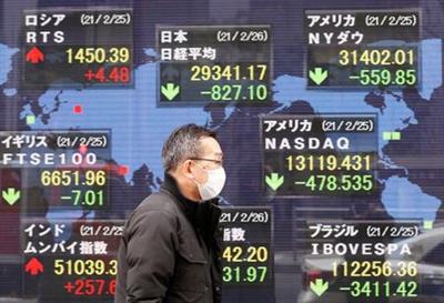 FILE PHOTO: A man walks past a stock quotation board at a brokerage in Tokyo, Japan February 26, 2021. REUTERS/Kim Kyung-Hoon 