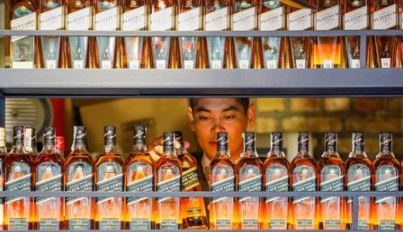 A bartender takes a bottle of Johnnie Walker whisky at Barmaglot bar in Almaty, Kazakhstan June 22, 2017. REUTERS/Shamil Zhumatov