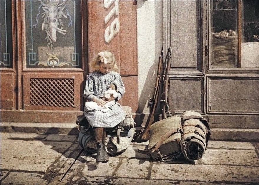 A Girl Holds A Doll Next To Soldiers