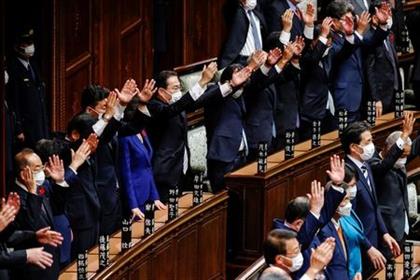 Japan's Prime Minister and the leader of the ruling Liberal Democratic Party (LDP) Fumio Kishida and his cabinet ministers raise their hands and shout 