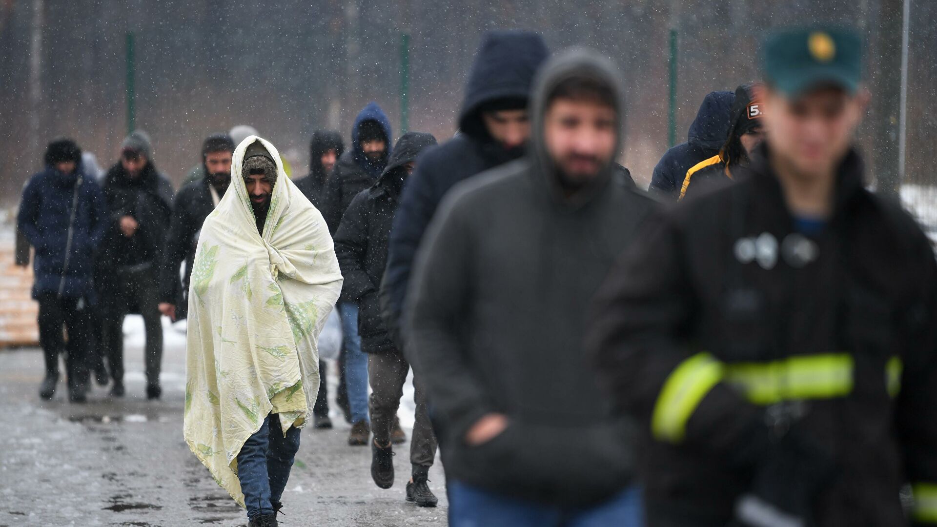 Беженцы с Ближнего Востока идут после купания в полевой бане в лагере мигрантов, оборудованном в логистическом центре в пункте пропуска Брузги на белорусско-польской границе - РИА Новости, 1920, 03.12.2021