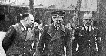 Слева направо: рейхсляйтер Мартин Борман, фюрер Адольф Гитлер, обергруппенфюрер НСКК Эрвин Краус.