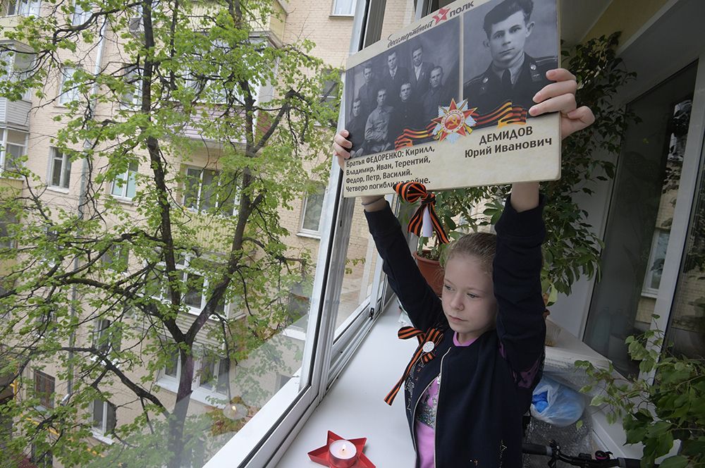 Девочка с портретами своих родственников - ветеранов Великой Отечественной войны, Москва.
