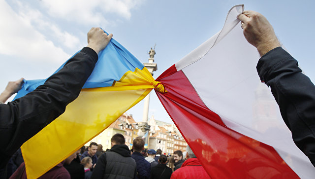 Люди держат связанные флаги Польши и Украины в Варшаве. Архивное фото.