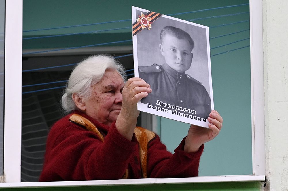 Пожилая женщина на балконе своего дома с портретом ветерана Великой Отечественной войны, Ростов-на-Дону.