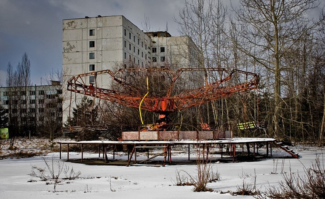 Чернобыль
Украина
Катастрофа на Чернобыльской АЭС превратила название городка в имя нарицательное. Спустя десятилетия после аварии, окрестности Чернобыля все еще сохраняют высокий радиационный фон — что делает удивительной информацию о все еще живущих здесь людях. Почти четыре сотни стариков решили вернуться в свои дома, находящиеся внутри запретной зоны. Кроме того, тысячи людей работают и на самом заводе, вынужденные проводить две вахтовые недели на близлежащей территории. Окрестные села, такие как Иваньковка, также не стоят покинутыми, хотя уровень радиации здесь в 30 раз превышает обычный.
