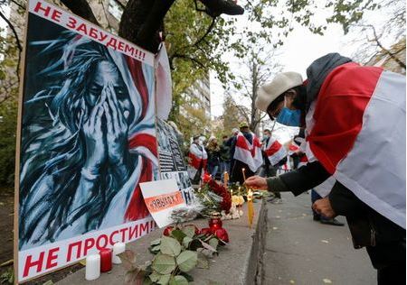People gather to mourn the death of Belarusian anti-government protester Roman Bondarenko, who was allegedly beaten by the country's security forces in Minsk, outside the Belarusian embassy in Kyiv, Ukraine November 13, 2020. A placard reads: 