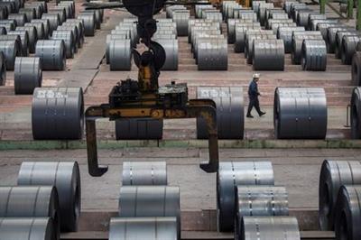 FILE PHOTO: A worker walks past steel rolls at the Chongqing Iron and Steel plant in Changshou, Chongqing, China August 6, 2018. REUTERS/Damir Sagolj