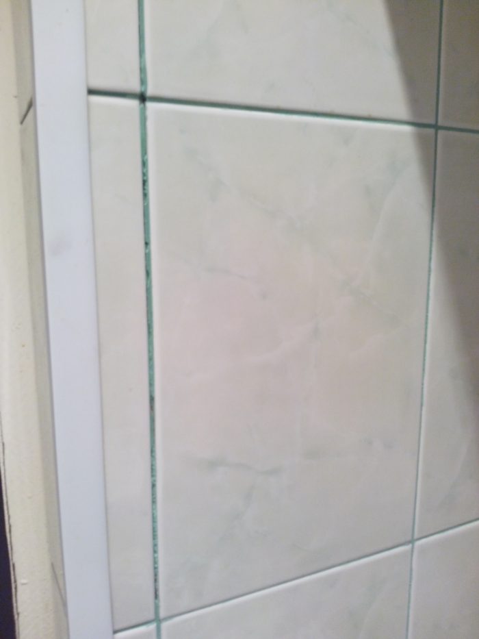 Почему отошла стена. Плитка отошла от стены. Отслаивающиеся кафельная плитка. Отходит плитка в ванной. Плитка в ванной отошла от стены.