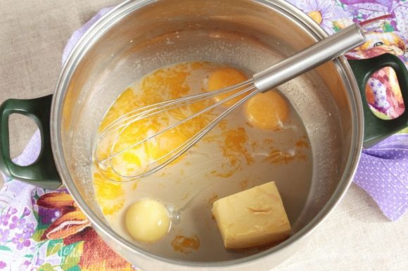 Добавить яичные куриные желтки (4 шт.) и масло сливочное (90 г) комнатной температуры. Тщательно перемешать, слегка взбивая венчиком.