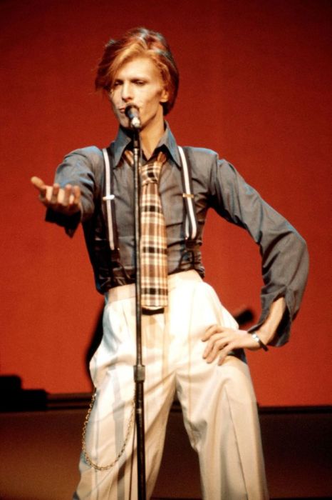 Британский певец выступает в Radio City Music Hall в сценическом костюме с подтяжками и галстуком в клетку.