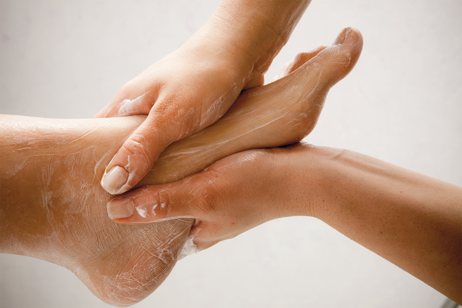 Работать пятки. Нанесение крема на ноги. Парафинотерапия для ног. Крем для кожей рук и ног. Холодная парафинотерапия для ног.