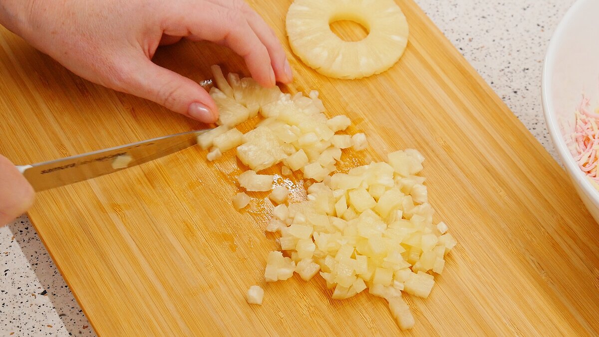Ананасы нарезаем мелкими кубиками и смешиваем с колбасой и сыром. 