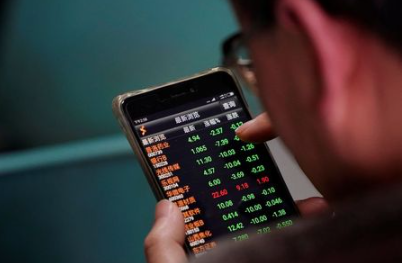 An investor checks stock information on a mobile phone at a brokerage house in Shanghai, China February 9, 2018. REUTERS/Aly Song