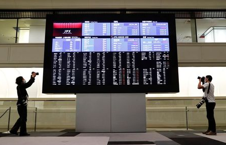 Photographers take photos near a large screen showing stock prices at the Tokyo Stock Exchange (TSE) after market opens in Tokyo, Japan October 2, 2020. REUTERS/Kim Kyung-Hoon