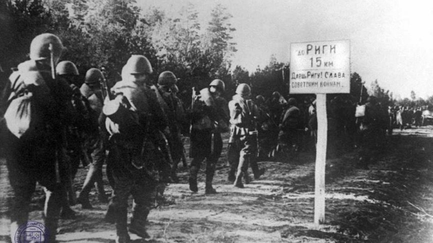 На дорожном указателе написано: «До Риги 15 километров. Даешь Ригу! Слава советским воинам».