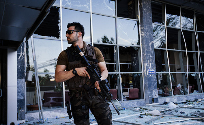 Сотрудник полиции возле разрушенной в результате попытки переворота штаб-квартиры полиции