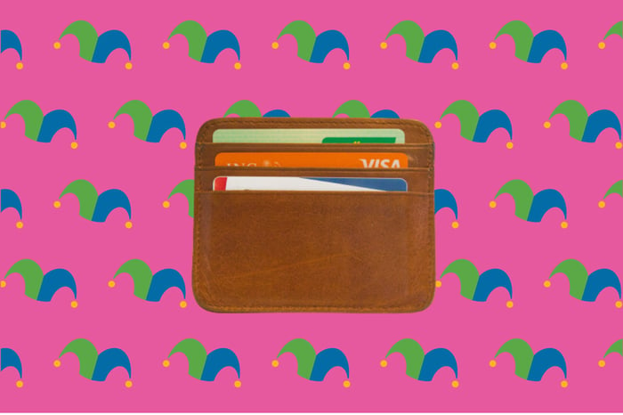 A wallet against a pink background.