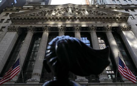 The back of the the "Fearless Girl" statue is pictured as morning sunlight falls on the facade of the New York Stock Exchange (NYSE) building after the start of Thursday's trading session in Manhattan in New York City, New York, U.S., January 28, 2021. REUTERS/Mike Segar