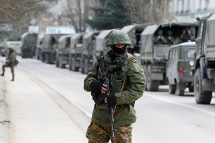 FILE PHOTO: Armed servicemen wait in Russian army vehicles outside a Ukranian border guard post in the Crimean town of Balaclava March 1, 2014. REUTERS/Baz Ratner/File Photo