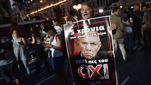 Демонстрант, протестующий против мер экономии в Греции, с портретом Вольфганга Шойбле