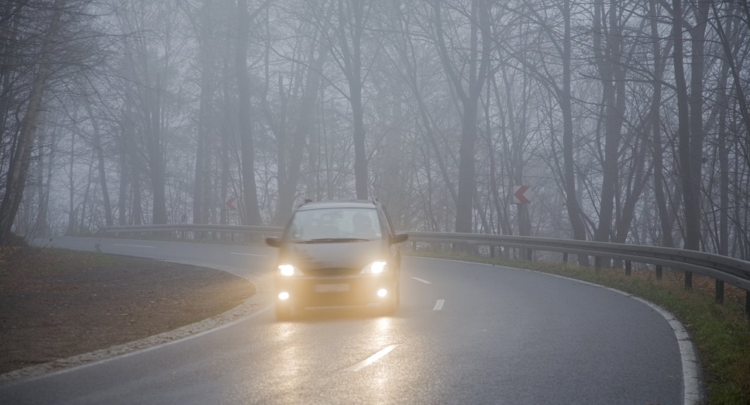 Машина на осенней дороге в тумане