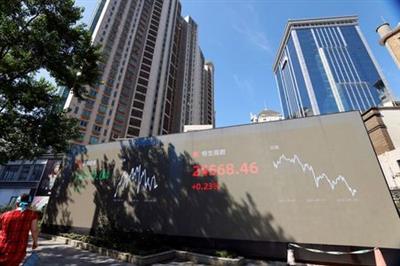 A woman walks by an electronic display showing the Shenzhen and Hang Seng stock indexes, in Shanghai, China, September 24, 2021. REUTERS/Aly Song