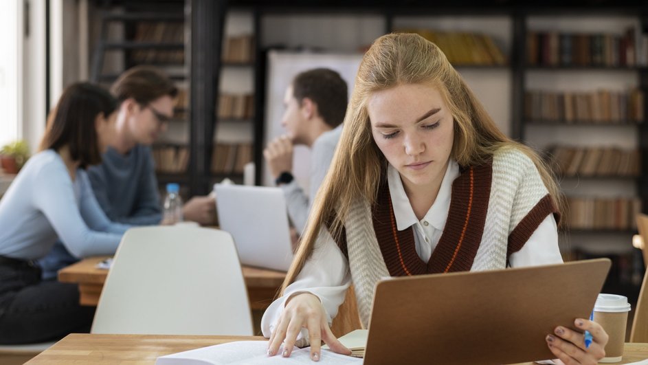 Школьница в библиотеке готовится к экзамену Школьница в библиотеке готовится к экзамену