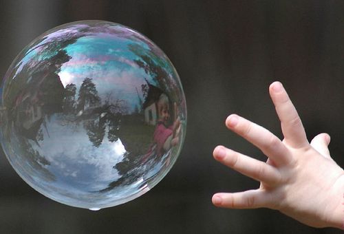 рука ребенка у мыльного пузыря