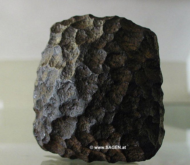 В 1885 году рабочий по имени Рейдл Бэк обнаружил артефакт возрастом 60 миллионов лет. Рабочий, обнаруживший загадочный артефакт, работал на литейном заводе в Шендорфе / Фёклабруке (Австрия), запущенном Исидором Брауном (1801-1866).  Рабочий вскрыл блок бурого угля, добытого в Вольфзегге, и обнаружил странный металлический предмет, встроенный в блок угля, который был назван "железом Вольфзегга".  Предмет показался необычным и значимым рабочему Ридлу и его товарищам по работе, и они отнесли его своему начальнику. Сын основателя литейного завода, Исидор Браун, отнес артефакт в Heimathaus (музей) в Фёклабруке.  В 1886 году горный инженер Адольф Гурльт, профессор геологии Боннского университета, предположил, что артефакт имеет метеоритное происхождение. Это было приемлемое объяснение неуместному артефакту. Ученые были довольны.  Артефакт хранился в Oberosterreichisches Landesmuseum в Линце, где оригинальный объект был выставлен на всеобщее обозрение с 1950 по 1958 год. Лишь в 1966-67 годах артефакт возрастом 60 миллионов лет был проанализирован в Венском естественно-историческом музее.   В результате проведенных исследований эксперты пришли к выводу, что это артефакт, который неопровержимо доказывает существование в доисторические времена древних цивилизаций, чье технологическое развитие превосходило современное человечество. Загадочный артефакт был попал в месторождение угля, возраст которого датируется примерно 60 миллионами лет.   Анализ проводился с помощью электронно-лучевого микроанализа, и в ходе анализа в железе не было обнаружено следов никеля, хрома или кобальта, что указывает на то, что объект не метеоритного происхождения, а отсутствие серы говорит о том, что это не пирит.  Дальнейшее исследование, проведенное Хубертом Маттлианером в 1973 году, позволило сделать вывод, что этот предмет был отлит по технологии cire perdue (Литьё по выплавляемым моделям). Доктор Геро Курат из музея и доктор Рудольф Гриль из Геологического бундесанштальта Вены также считали, что это может быть чугун из-за низкого содержания магния в предмете,  Вот описание загадочного артефакта возрастом 60 миллионов лет:  "Объект был почти кубом, с двумя противоположными гранями, слегка закругленными. Его размеры составляли 67 мм на 47 мм, причем последнее измерение проводилось между двумя закругленными гранями. Он весил 785 граммов. Вокруг него был очень глубокий разрез. По своему составу он состоял из твердой стали с никелем и углеродом. Он не содержал серы и, следовательно, не был пиритом".  Некоторые эксперты утверждают, что края предмета были острыми и прямыми, и почти не было сомнений в том, что это был инструмент машинного производства, который казался частью гораздо большего инструмента.  Если этот объект не упал из космоса, то он является доказательством существования развитой цивилизации на Земле миллионы лет назад. Эта цивилизация имела доступ к передовым технологиям, а многие другие загадочные объекты, обнаруженные по всему миру, указывают на то, что это не единичные артефакты, а множество предметов исчезнувшей миллионы лет назад развитой цивилизации.  В СМИ это артефакт называют "Зальцбургский параллелепипед" и обычно утверждается, что он бесследно исчез в 1910 году из музея Зальцбурга. Однако, это не так и он находится в музее Heimathaus в Вёклабруке, Австрия.  Просто он уже не выставляется на всеобщее обозрение. Объяснить его современная наука не может, а подтверждать тот факт, что 60 миллионов лет назад на Земле существовала развитая цивилизация она не будет.  За последние столетия, ученые тщательно выстроили "нужную" картину человеческой истории - написаны книги, огромное количество научных трудов, защищены диссертации, получены должности и звания...   Перешагнуть все это сможет далеко не каждый ученый и, как мы видим годы идут, а отношение науки к "неуместным артефактам" совсем не меняется.