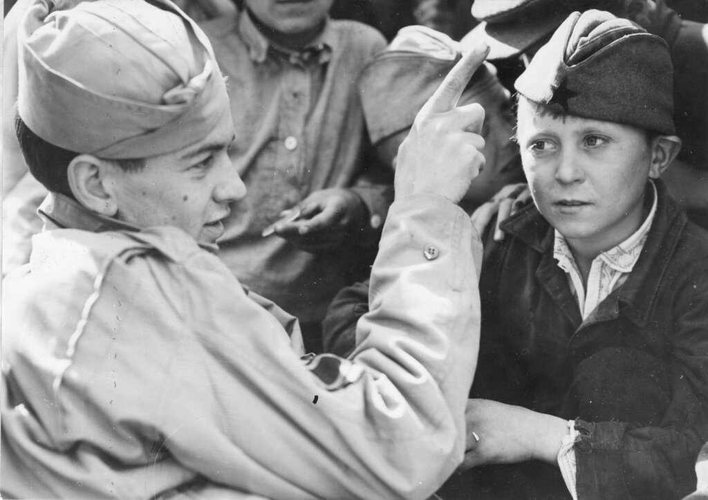 Техник-сержант Джозеф Е. Томпсон учит советского мальчика английским словам. 1944 г.