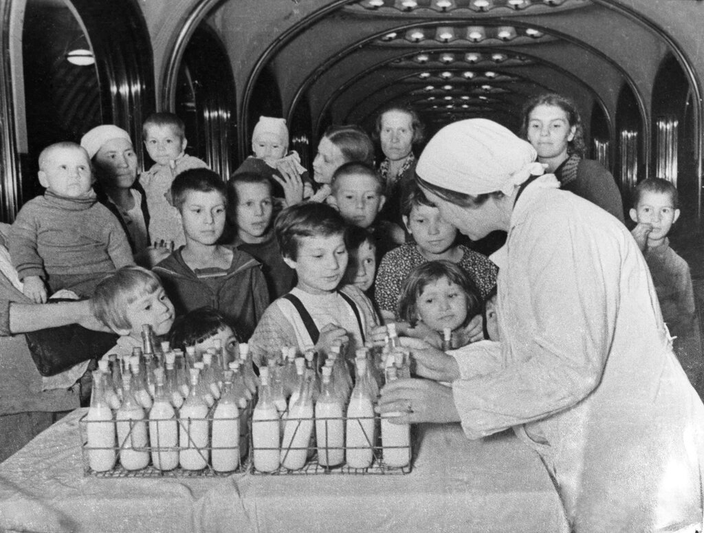 В московском метро, на станции «Маяковская», используемой как бомбоубежище, идет раздача молока детям. Январь 1942