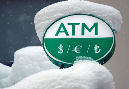 Turkish Lira (TL) and international currency symbols are seen over a snow-covered ATM machine of a bank in central Istanbul, Turkey January 9, 2017. REUTERS/Murad Sezer