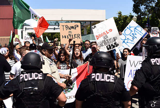 Демонстрация противников Трампа 27 мая 2016: надписи на плакатах «Трамп = Гитлер», «Трамп — задница» 