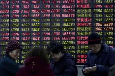 FILE PHOTO: Investors stand in front of an electronic board showing stock information on the first trading day after the week-long Lunar New Year holiday at a brokerage house in Shanghai, China, February 15, 2016. REUTERS/Aly Song/File Photo