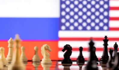 Chess pieces are seen in front of displayed Russian and U.S. flags in this illustration taken January 26, 2022. REUTERS/Dado Ruvic/Illustration