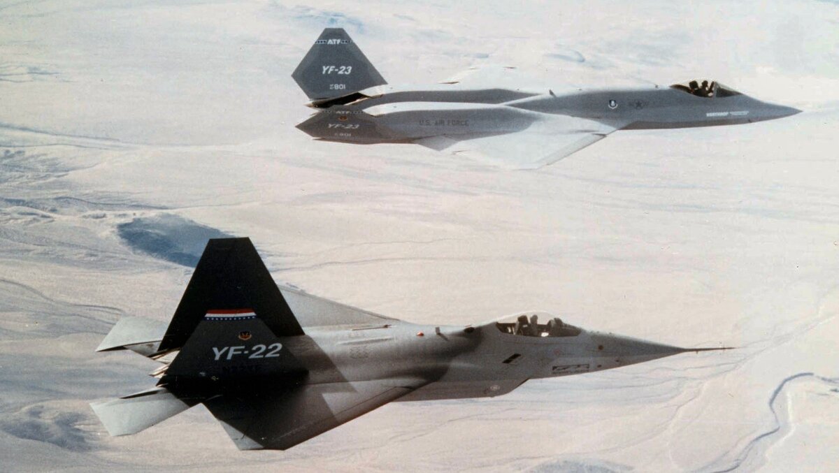 YF-22 (на переднем плане) и YF-23 (на заднем плане). Победителем в конкурсе на создание истребителя пятого поколения стал YF-22, на базе которого был разработан F-22. 