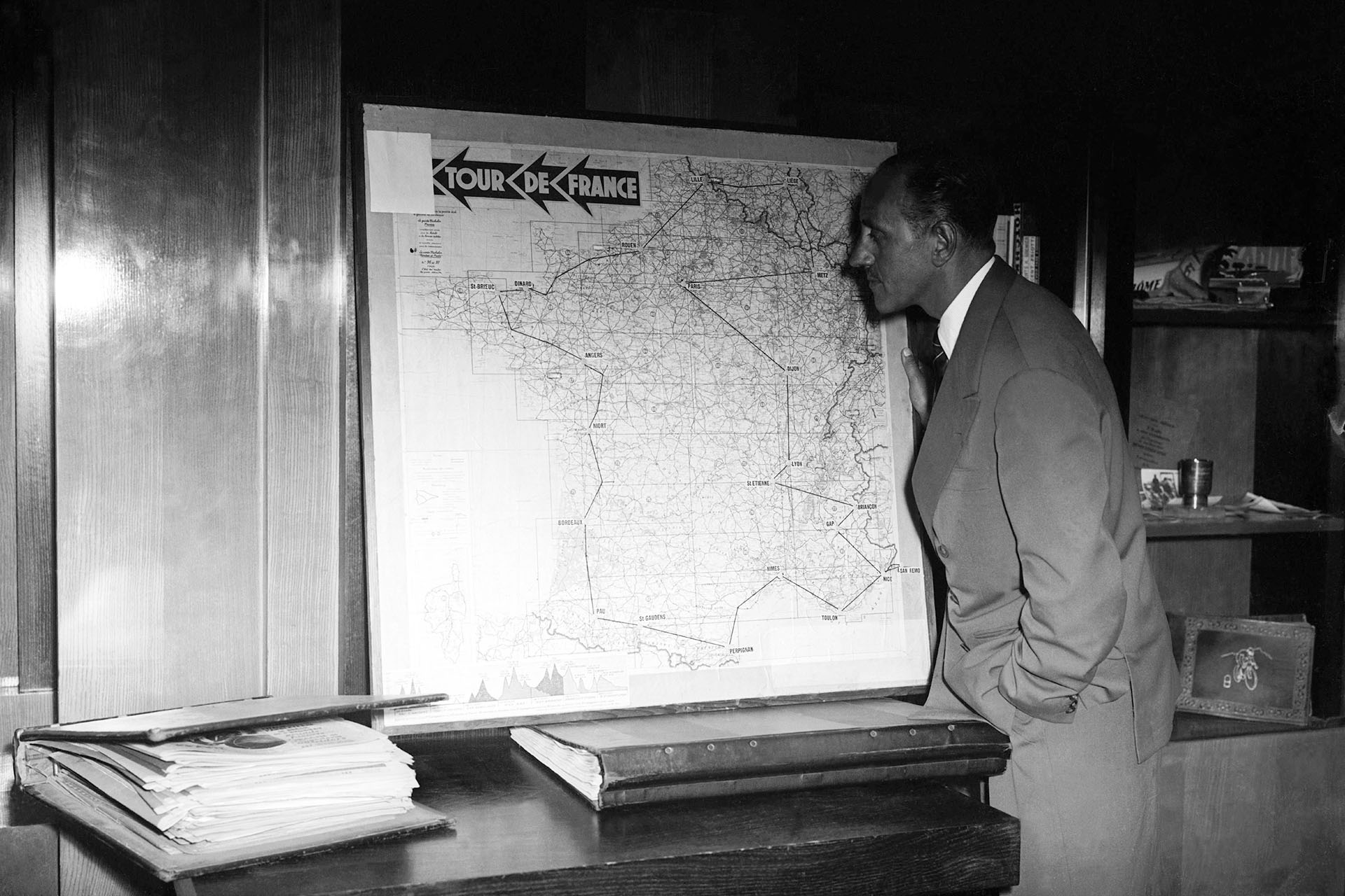Жак Годде, ставший директором Тур де Франс в 1936 году, сфотографироован в период с 1936 по1953 год на фоне карты тура
