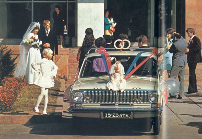 Молодожены, фотографирующиеся перед Дворцом бракосочетания. СССР, 1970 год.