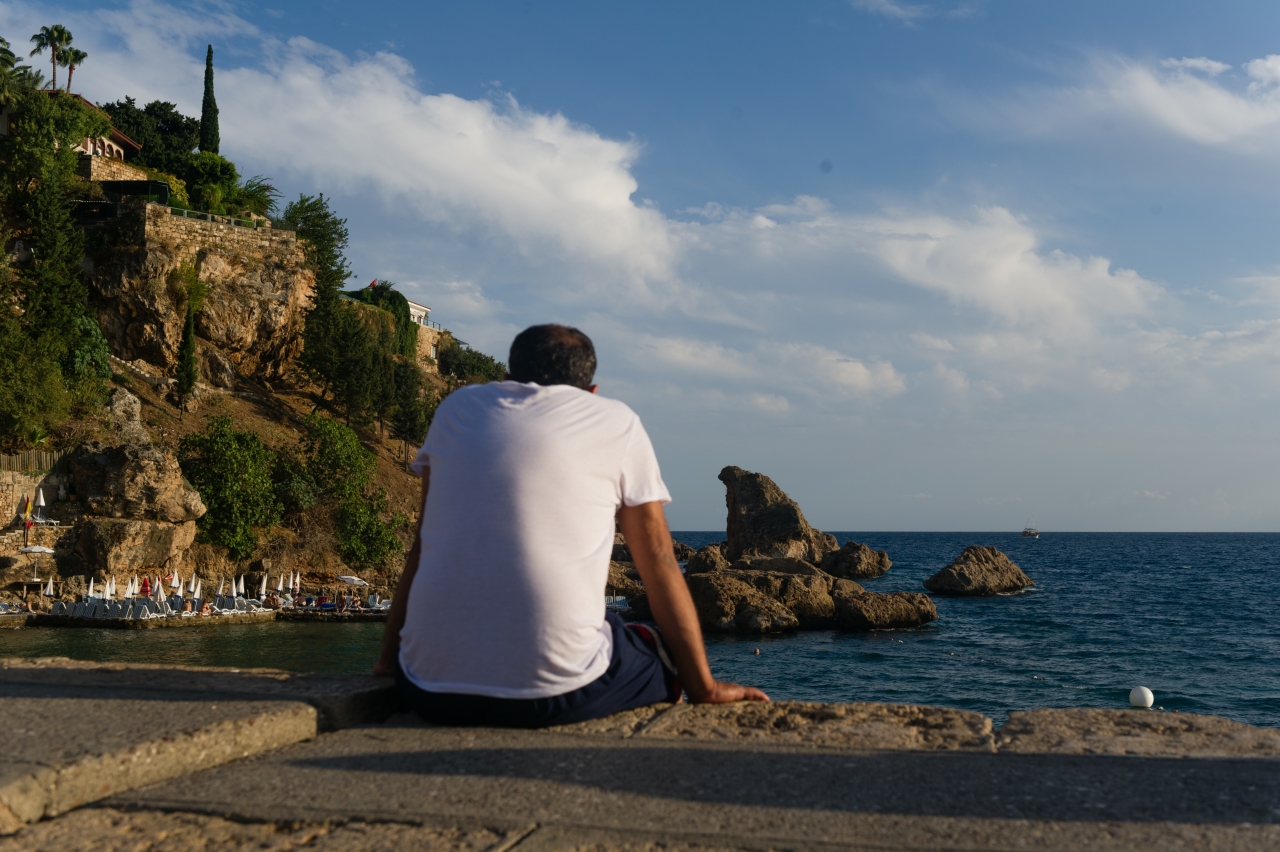 одинокие мужчины в турции. парень сидит на берегу моря. охрана ресторана. туроператоры за границей. турция отдых парни.