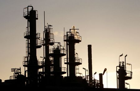 FILE PHOTO: Towers and smokestacks are silhouetted at an oil refinery in Melbourne June 21, 2010. REUTERS/Mick Tsikas/File Photo