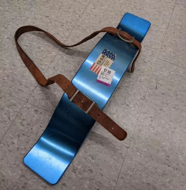 Изогнутая металлическая деталь с прикрепленным кожаным ремнем