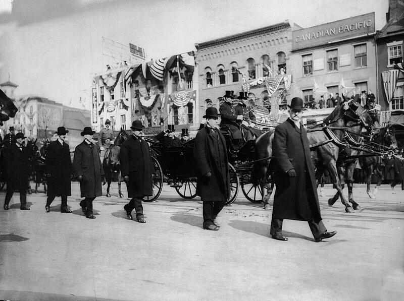 Агенты секретной службы ходят по обеим сторонам экипажа президента Теодора Рузвельта во время его инаугурации 4 марта 1905 года. Он был первым президентом, которому была предоставлена защита секретной службы.