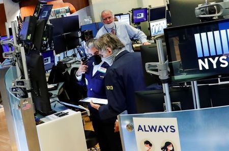 Traders wearing masks work, on the first day of in person trading since the closure during the outbreak of the coronavirus disease (COVID-19) on the floor at the New York Stock Exchange (NYSE) in New York, U.S., May 26, 2020. REUTERS/Brendan McDermid