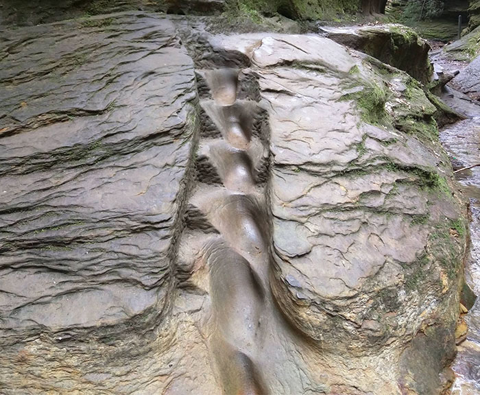 A Nicely Worn Staircase Into The Stone Wall Above A Creek