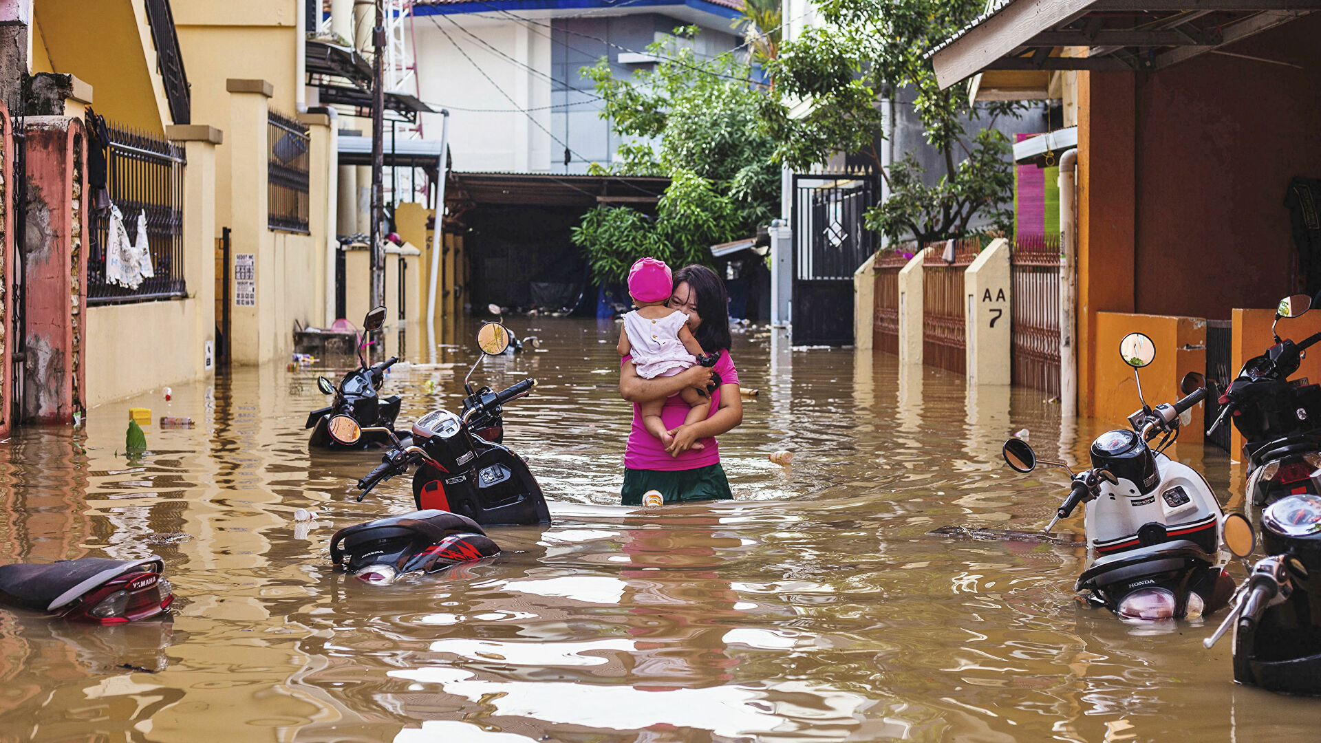 Женщина несет свою дочь во время наводнения в Макассаре, Индонезия - РИА Новости, 1920, 05.11.2021