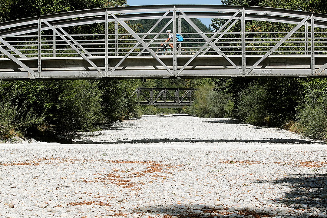 Велосипедист проезжает по мосту над пересохшей рекой в Швейцарии. Фото: REUTERS