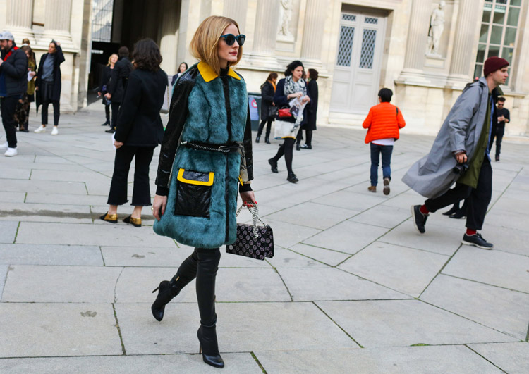 Olivia Palermo в черных джегинсах, ботильоны и пальто с зеленым мехом