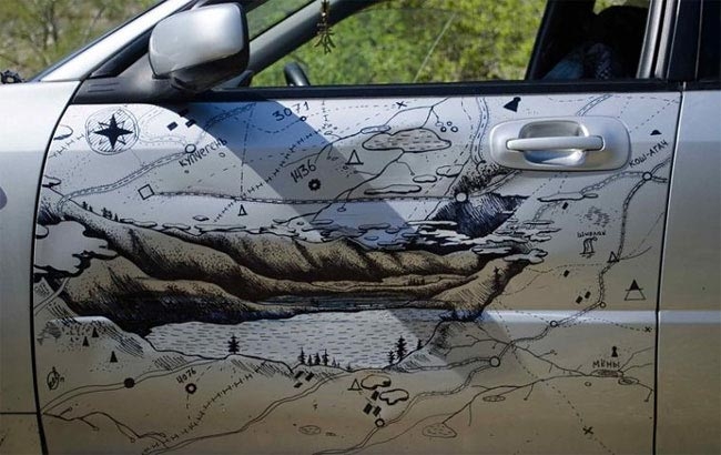 творческий способ исправить вмятину, нарисовал горы и карту на вмятине, нарисовал горы и карту на двери автомобиля