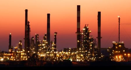 The chimneys of the Total Grandpuits oil refinery are seen just after sunset, southeast of Paris, France, March 1, 2021. REUTERS/Christian Hartmann